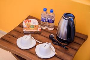 a table with a tea kettle and two bottles of water at ABS Villa Bentota in Bentota