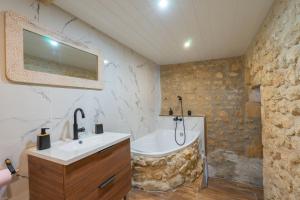 ein Badezimmer mit Waschbecken und Badewanne in der Unterkunft Napoléon in Saint-Genis-de-Saintonge