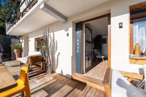 une terrasse en bois avec une porte coulissante en verre sur une maison dans l'établissement Le Moulin de Navette, à Navette