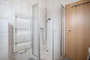 a shower with a glass door in a bathroom at Günther - Ferienwohnungen Zinnowitz in Zinnowitz +13 photos