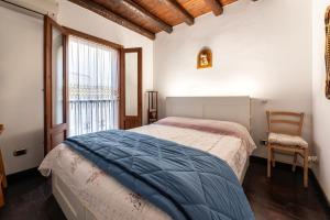 ein Schlafzimmer mit einem Bett, einem Fenster und einem Stuhl in der Unterkunft Casa Margherita in Porticello