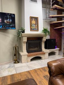 Una sala de estar con chimenea y televisión. en Guest house LORA, en Gabrovo
