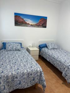 Un dormitorio con dos camas y un cuadro en la pared. en Villa Vera, en Playa Blanca