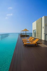 a row of chaise lounges on a dock in the water at Sofia Colombo City Hotel in Colombo