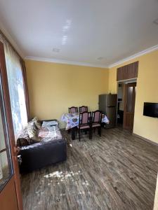 a living room with a couch and a table and chairs at Arpi GuestHouse Dilijan in Dilijan