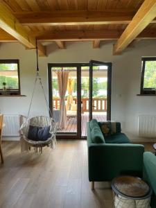 un soggiorno con divano verde e altalena di Mahoniówka Mikołajki a Wawrowice