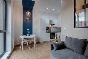 un salon avec un canapé et une table dans l'établissement Proche Gare, parking couvert, Wifi, à Bourgoin-Jallieu