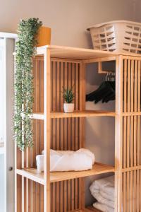 une étagère en bois avec des plantes en pot dans une pièce dans l'établissement Casa Luma, à Cascais