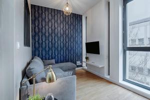 un salon avec un canapé et une télévision dans l'établissement Proche Gare, parking couvert, Wifi, à Bourgoin-Jallieu