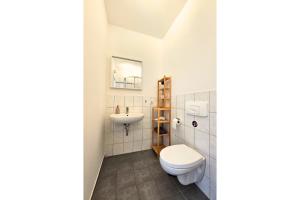 a bathroom with a toilet and a sink at LUMA Apartments in Dresden +53 photos