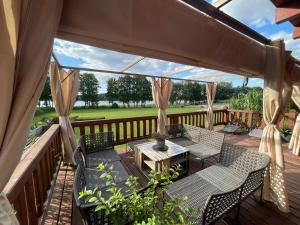 una terrazza in legno con sedie, tavolo e tavolo di Mahoniówka Mikołajki a Wawrowice