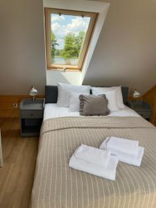 una camera da letto con un letto grande con due asciugamani sopra di Mahoniówka Mikołajki a Wawrowice