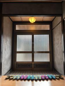 a room with a door with a bunch of shoes at 岳見の宿 天然温泉とプライベートサウナの一棟貸しヴィラ in Yufuin +24 photos