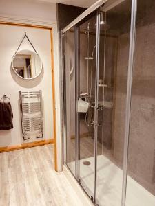 eine Glasdusche in einem Badezimmer mit Spiegel in der Unterkunft Stylish & Spacious Victorian Home near Severn Valley Railway & Safari Park in Kidderminster