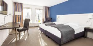 een hotelkamer met een bed en een bureau en een bureau bij Das Goldene Lamm Aalen in Aalen