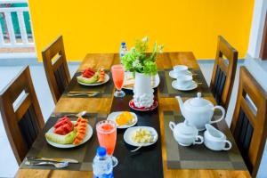 a wooden table with plates of food on it at ABS Villa Bentota in Bentota