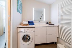 a white laundry room with a washing machine and a sink at Le Rêve 210 in La Tranche-sur-Mer +17 photos