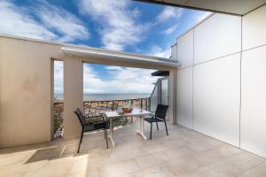 a balcony with a table and chairs and a view of the ocean at Le Rêve 210 in La Tranche-sur-Mer
