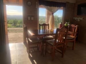 Arroyo de Los PatosにあるCasita El Mirador Traslaのテーブルと椅子と窓のあるダイニングルーム