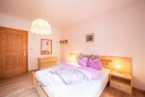 a bedroom with a bed with purple pillows on it at Sonnenparadies Apartement 3 in Saltusio