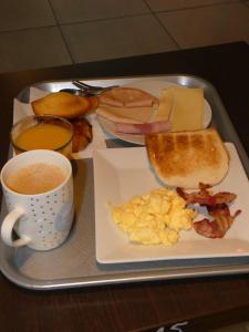 a tray with a plate of food and a cup of coffee at ibis Saintes in Saintes
