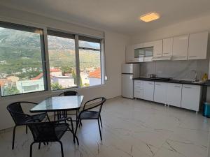 a kitchen and dining room with a table and chairs at Apartmani Kula in Pečurice