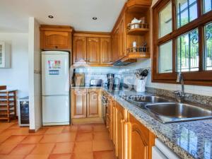 カロンジェにあるCasa Bellotaの木製のキャビネットと白い冷蔵庫を備えたキッチン