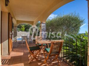 um pátio com uma mesa e cadeiras em uma varanda em Casa Bellota em Calonge