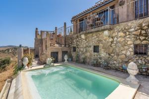 AlgarinejoにあるErmita de las erasの石造りの建物の前にある屋外スイミングプール