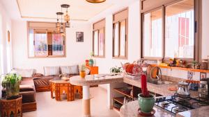 a kitchen and living room with a stove top oven at Atlantic Vibes Surf Hostel in Tamraght Ouzdar