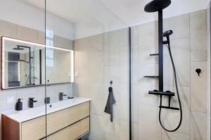 a bathroom with a shower and a sink at Le Poinsettia d'Or T3 élégant proche Maïdo & piscine in Le Bois de Nèfles +27 photos