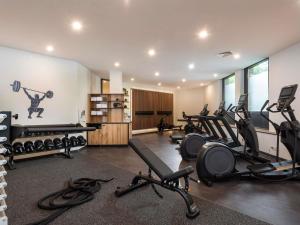 Un gimnasio con cintas de correr y equipos de ejercicio en una habitación. en Mercure Hotel München Neuperlach Süd, en Múnich 111 fotos más