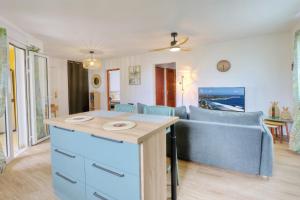 a living room with a blue couch and a table at Le Poinsettia d'Or T3 élégant proche Maïdo & piscine in Le Bois de Nèfles