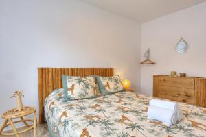 a bedroom with a bed with a wooden headboard at Le Poinsettia d'Or T3 élégant proche Maïdo & piscine in Le Bois de Nèfles