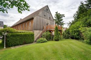 a large wooden building with a staircase in a yard at Ferienwohnung 'Zur Napoleonschanze' in Rathewalde