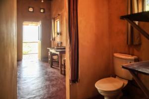 Tree House Cottage, Ocean View في بارايا دو توفو: حمام مع مرحاض وطاولة ونافذة