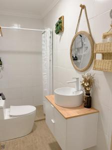 une salle de bain blanche avec un lavabo et une baignoire dans l'établissement The Cozy Cottage Semporna, à Semporna