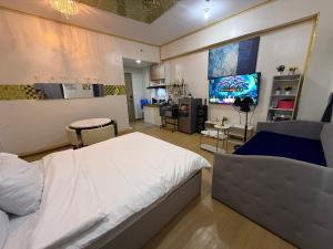 een slaapkamer met een bed en een tv erin bij HOPE RESIDENCES UNIT 606 building D in Trece Martires