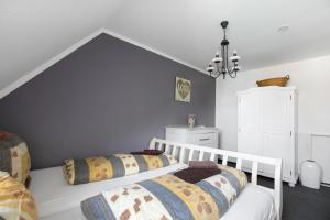 a bedroom with two beds and a chandelier at Schwalbennest in Klanxbüll