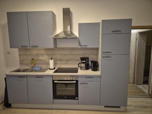 a kitchen with white cabinets and a stove top oven at Monteurswohnungen - Klein Wanzleben in Klein Wanzleben