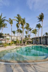 a large swimming pool with palm trees in a resort at Casa Andina Standard Piura in Piura