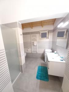 a white bathroom with a sink and a toilet at La Perla del Mare in Pisciotta