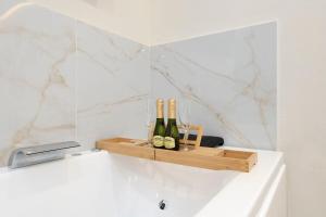 a shelf with wine bottles and glasses on a counter at EXCLUSIVE APARTMENT JACUZZi in Málaga