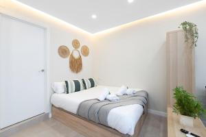 a white bedroom with a bed with white sheets and pillows at EXCLUSIVE APARTMENT JACUZZi in Málaga