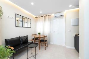 a living room with a black couch and a table at EXCLUSIVE APARTMENT JACUZZi in Málaga