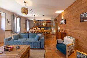 un salon avec un canapé bleu et une table dans l'établissement Chaleureuse Fruitière – 8 personnes, à Samoëns