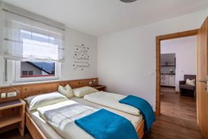 a bedroom with two beds and a window at Schnitzer Ferienwohnung Enzian in Rablà