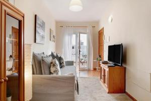 a living room with a couch and a tv at Luminoso ático en Arrecife in Arrecife