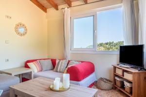 a living room with a couch and a tv at Arianna Grand apartment in Corfu