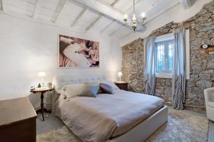 een slaapkamer met een groot bed en een stenen muur bij Casa Collicello relax in Camaiore +37 foto's